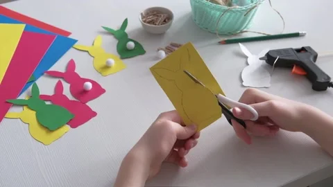 Boy made Easter paper garland. Hands cut out with scissors silhouette of easter Stock Footage 150192262