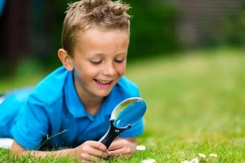 Boy with magnifier Stock Photos