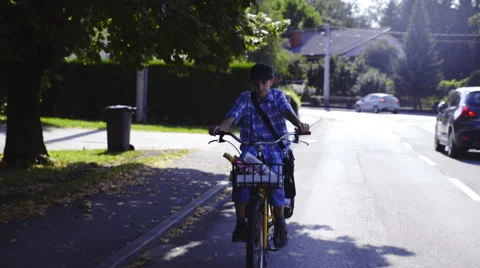 Boy mailman on bicycle throwing newspaper 4K Stock Footage 54055996