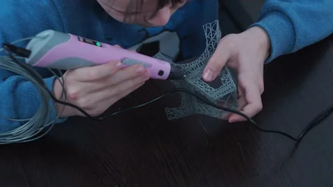 A boy makes a 3 d model with a pen. assembling the layout of the elfin tower Stock Footage 146735781