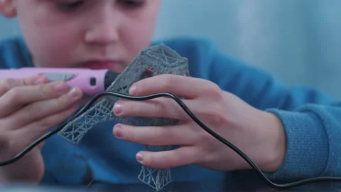 A boy makes a 3 d model with a pen. assembling the layout of the Elfin tower Stock Footage 146976899