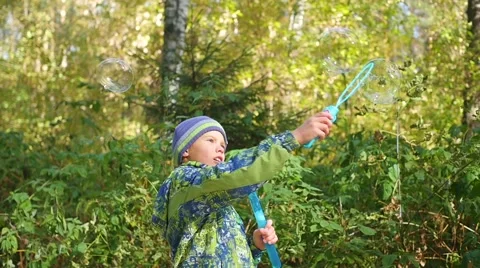 Boy makes big soap bubbles in the Park Video stock 68202584