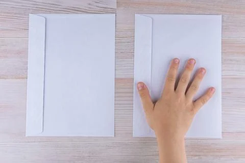 The boy makes a choice of two envelopes, laying his hand on the right, reduce Stock Photos