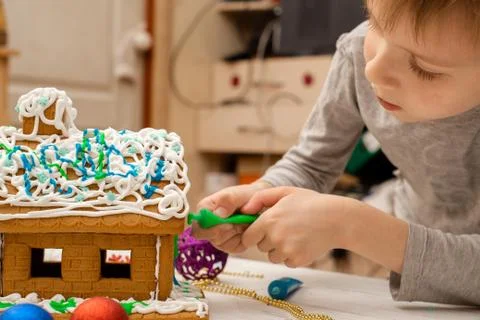 The boy makes a gingerbread house. Preparing for the holiday, creative activi Stock Photos