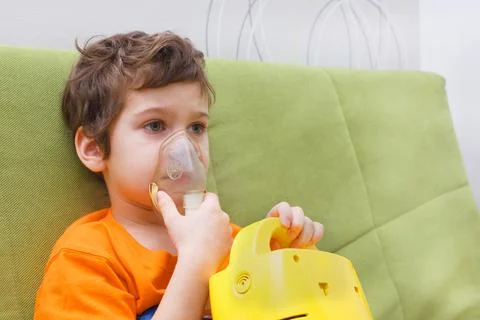 Boy makes inhalation through a nebulizer Stock-Fotos