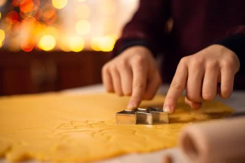Boy makes shortbread of christmas tree form on the table Stock Photos