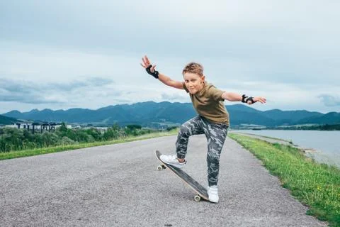 Boy makes a trick on skateboard Stock Photos