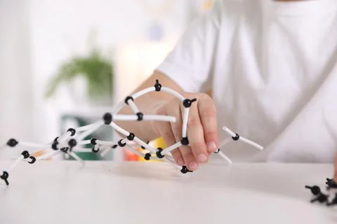 Boy making DNA structure model at desk indoors, closeup. Space for text Stock Photos