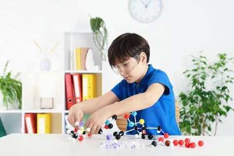 Boy making DNA structure model at desk indoors Stock Photos