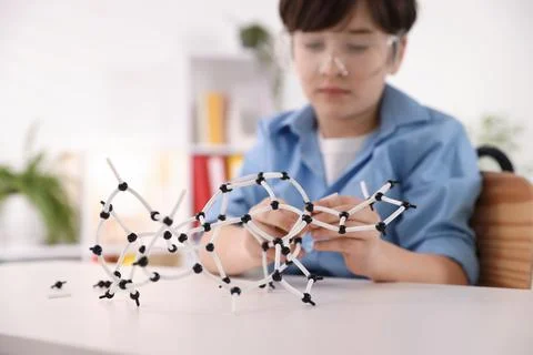 Boy making DNA structure model at desk indoors, selective focus 스톡 사진