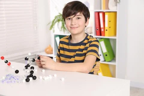Boy making DNA structure model at desk indoors 스톡 사진