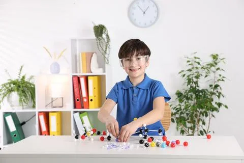 Boy making DNA structure model at desk indoors. Space for text Stock Photos