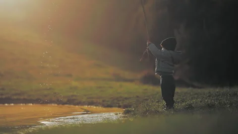 Boy making drops splash with a stick Stock Footage 254003442