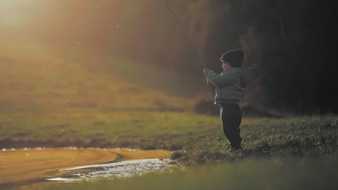 Boy making drops splash with a stick Stock Footage 254004665