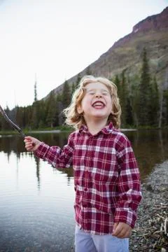 Boy making a face by still rural lake Stock Photos
