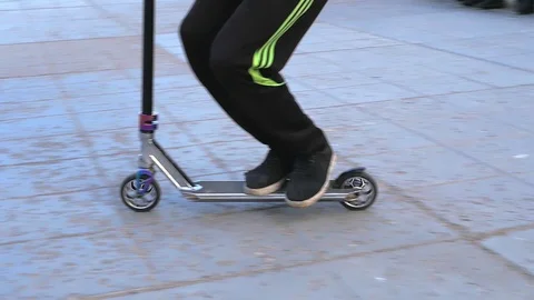 A boy is making a feat on his scooter in a summer park. Stock Footage 117930152