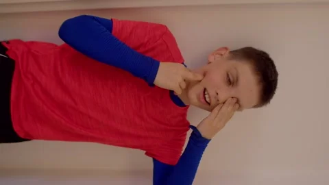 A Boy Making Funny Faces and Gestures Against a Wall for Fun and Joy Stock Footage 311204433