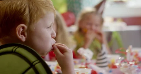 Boy making funny faces with a slice of fruit in his mouth Stock Footage 58573841