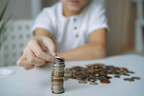 Boy making pyramide of coins. ABC of finance. boy counting money Stock-Fotos