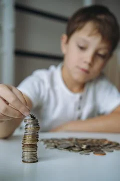 Boy making pyramide of coins. ABC of finance. boy counting money 写真素材