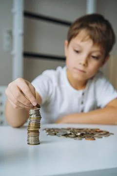 Boy making pyramide of coins. ABC of finance. boy counting money Fotos de archivo