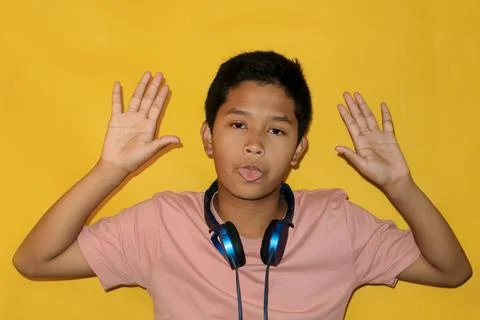 A boy is making a silly face while wearing headphones. Stock Photos