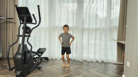 Boy making small fast jumps on both feet at home, Concept of child cardio and Stock Footage 341865383