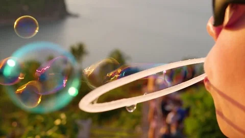 The boy is making soap bubbles. Closeup. Panoramic view. Sunset Vidéo 74787468