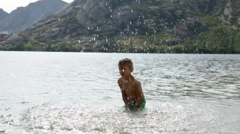 Boy making splashes in the lake Video stock 27093021