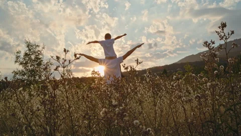 A boy on a man's shoulders, with the setting sun in the background. Stock Footage 298605548