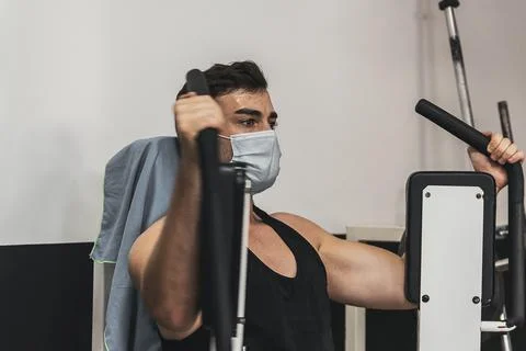 Boy with mask doing chest exercise in gym Stock Photos