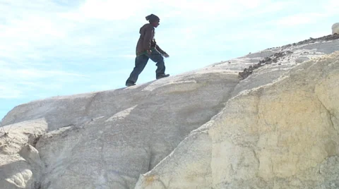 Boy meanders along top of rock formation. Stock Footage 27759854