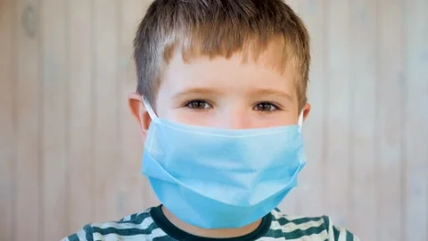 Boy in medical facemask looking at camera. Coronavirus, covid-19 outbreak. Brown Stock Footage 136659011