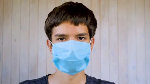 Boy in medical facemask looking at camera. Coronavirus, covid-19 outbreak. Brown Stock Footage 137503265