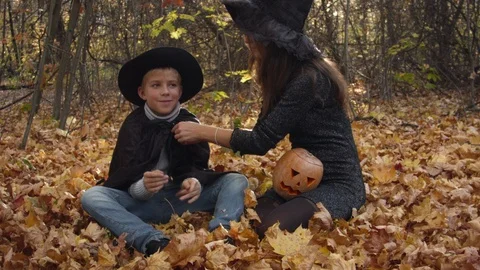 Boy with mom in halloween costumes play in the autumn forest. 스톡 동영상 123647404