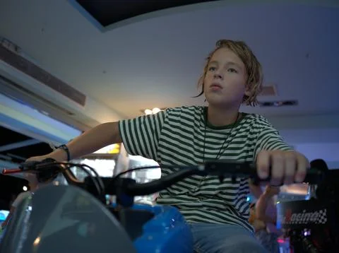 Boy on a motorcycle simulator in an arcade Stock Photos