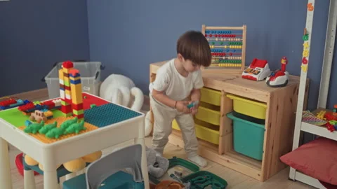 Boy moves abacus beads with hand on wooden table in a building playroom sur.. Stock Footage 339247917