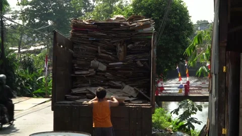 A boy moving cardboard into a tailgate Stock Footage 159778502