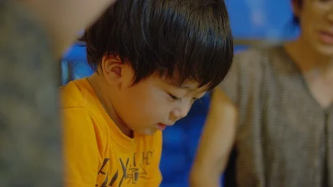 Boy. Multi-generation family serving and eating food at home. Stock Footage 100834538