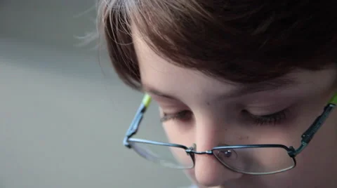 Boy with myopia reading, gazing and concentrating while wearing eyeglasses Stock Footage 60808463