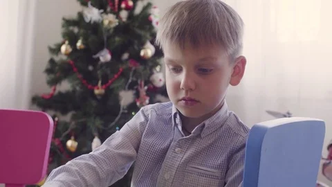 A boy near christmas tree doing something Stock Footage 76557774