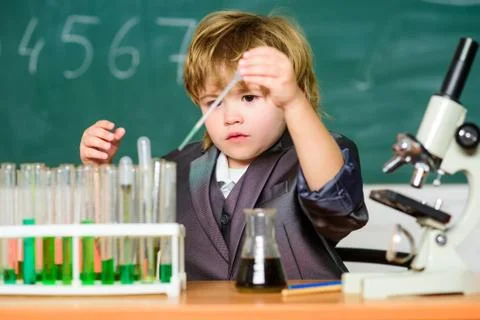 Boy near microscope and test tubes in school classroom. Science concept. Gifted Stock Photos