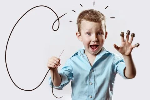 A boy with a needle and thread in a blue shirt on a light background Stock Photos