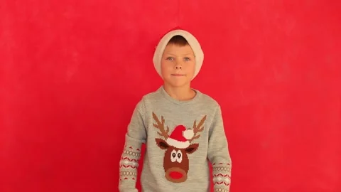 Boy in a New Year's cap and sweater on a red background. Stock-Footage 160521327