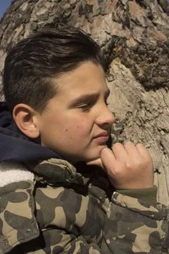 Boy next to a tree trunk. Stock Photos