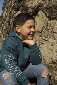 Boy next to a tree trunk. Stock Photos