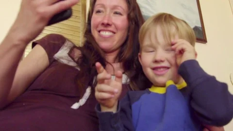 Boy is not really into taking selfie with mom Stock Footage 75056796