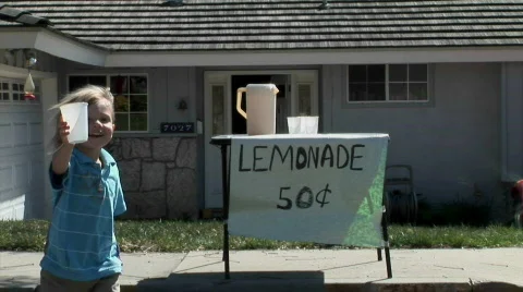 A boy offers a cup at a lemonade stand. Stock Footage
