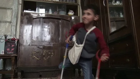 Boy with one leg playing inside, Kobani, Syria Видео 75958814