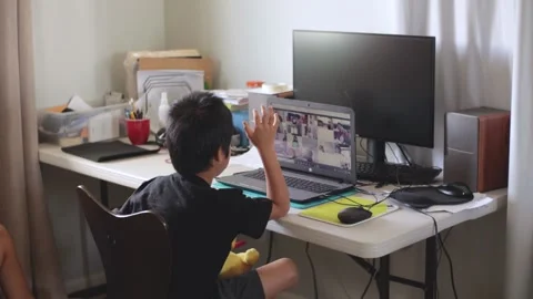Boy online distance learning at home on laptop computer, raising hand to teacher Stock-Footage 155898924